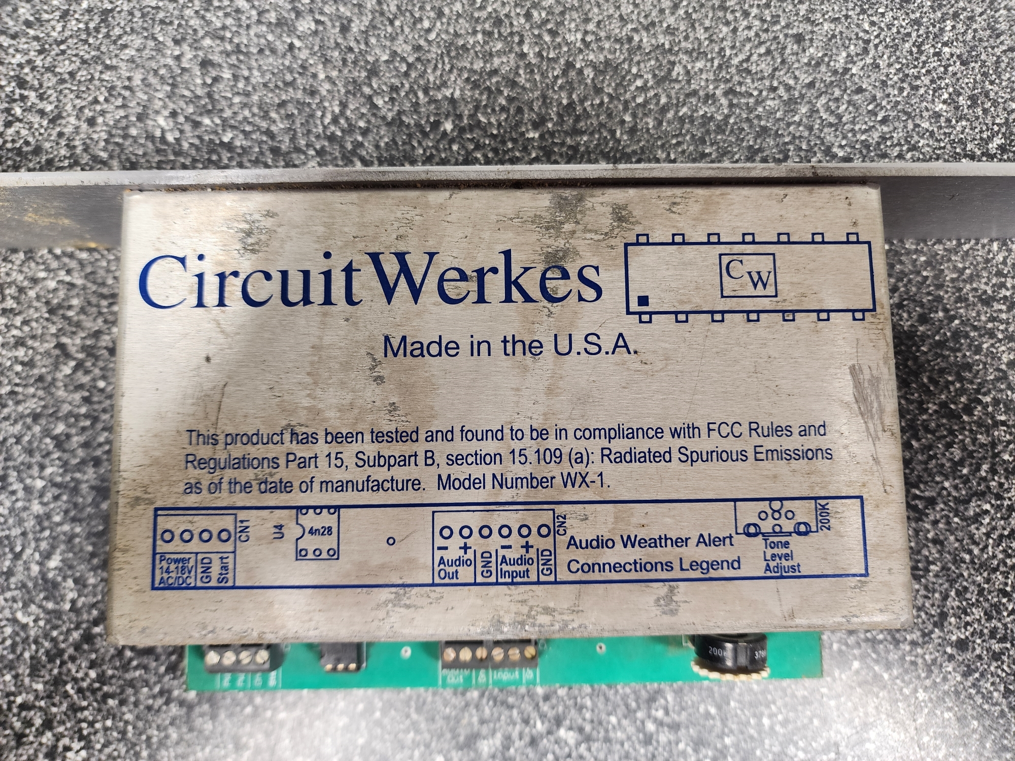 Picture 2: A top-down view of the WeatherStar Jr Audio Alert. At the top, in big font, it reads: 'CircuitWerkes' next to a logo of a microchip. 'Made in the U.S.A.' The following smaller text reads 'This product has been tested and found to be in compliance with FCC Rules and Regulations Part 15, Subpart B, section 15.109 (a): Radiated Spurious Emissions as of the date of manufacture. Model Number WX-1.' There is a diagram detailing the terminal block layout at the bottom.